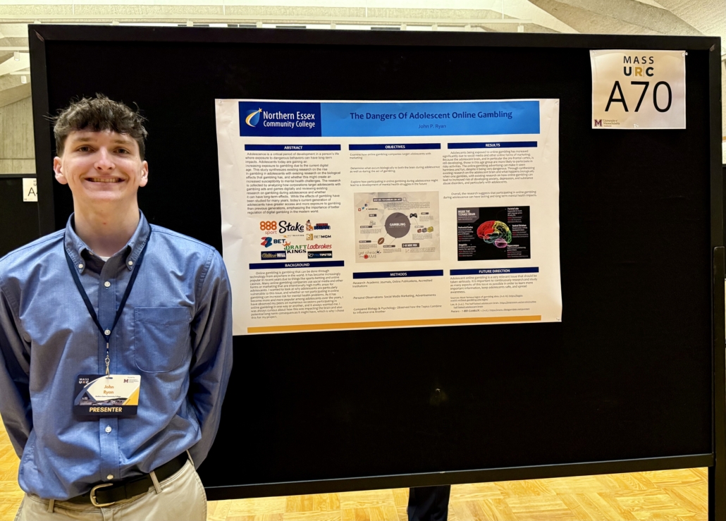 John Ryan stands next to his research poster