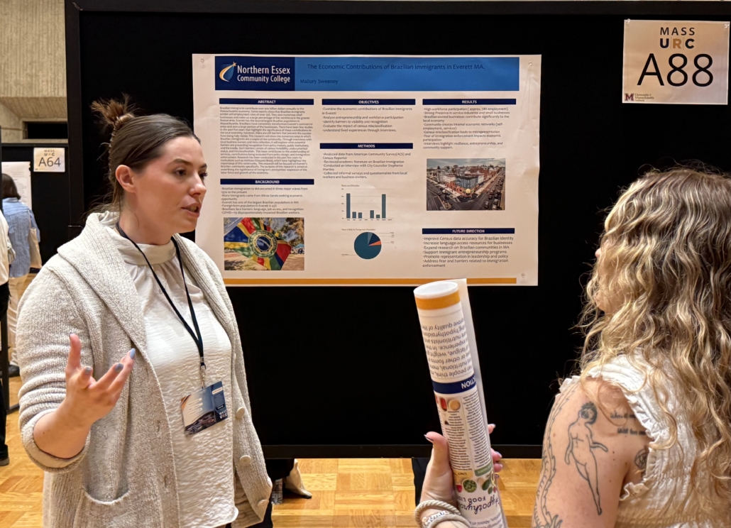 Mallory Sweeney and Liz Dobson in discussion in front of a research poster