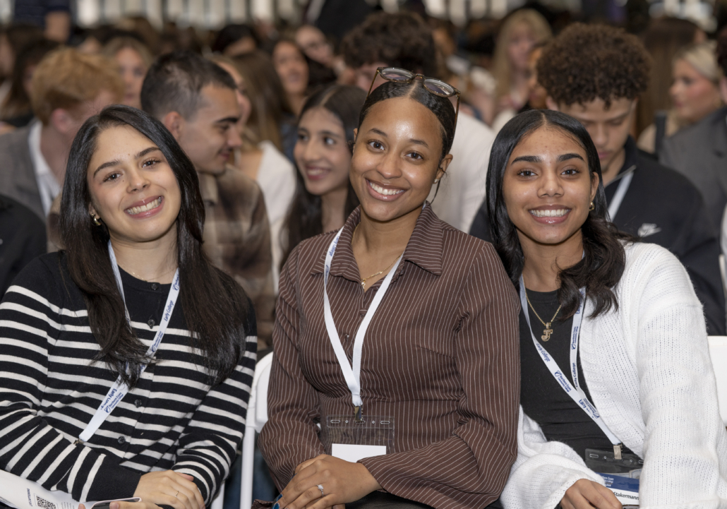 three young women smile at camera