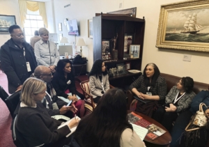 A group of adults sitting in an office space discussing matters