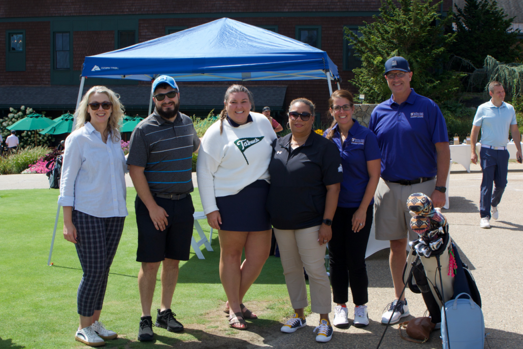 group of student and academic staff post in front of popup tent