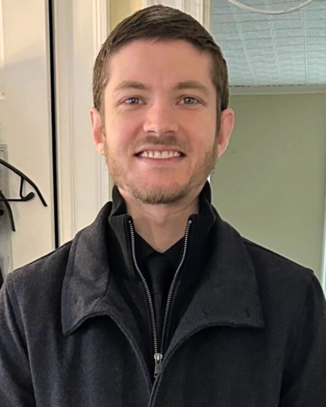 Nick stands smiling at camera
