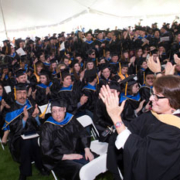 wide shot of room full of graduates in caps and gowns