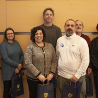 Three women and three men pose with their NECC gift bags