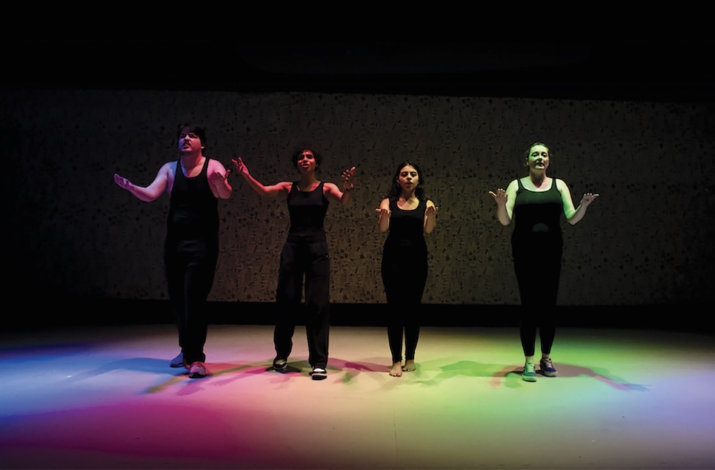 NECC theater performers performing under rainbow lights on stage