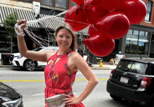 Hailey holding red balloons on the streets of Haverhill