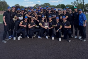 KNights team stands in black uniforms with black hats holding tournament trophy