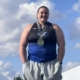 Maci stands with medal around her neck smiling at camera