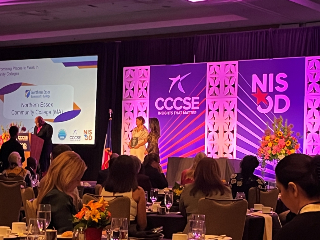 wide shot of stage with NISOD Banners and two people accepting an award