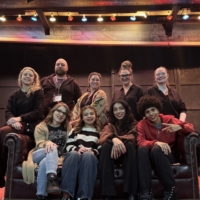 group of students pose on a stage smiling at camera