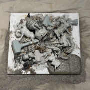 exhibit of found ceramic objects affixed to a burlap backing