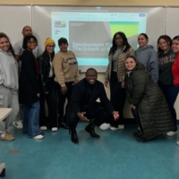 a group of students pose in front of projection screen