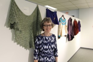Lynne Nadeau, organizer of the NECC Fiber Arts Exhibit, stands in front of the leaf lace shawl she knit.