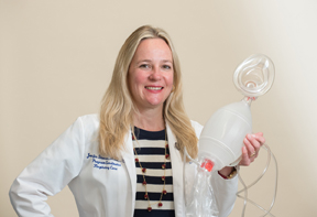 Jennifer Jackson Stevens holding a breathing device used in respiratory care.