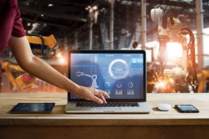 graphic of a person reaching for a laptop keyboard with robotic automation in the background.
