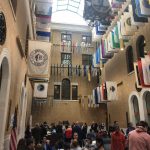 large atrium-style room with lots of windows and a flag hanging representing the 351 cities and towns in Massachusetts