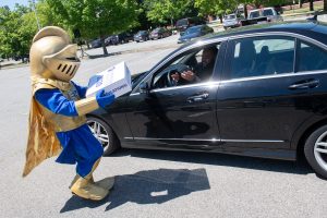 Knight mascot delivers package to NECC 2020 grad in car.