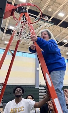 PHOTO: NECC Academic Coach Gretchyn Gallagher cuts the net at the NJCAA East Regional Tournament.