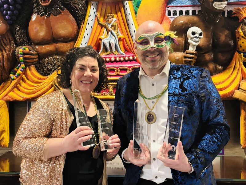 Melissa Bouse and Keith Paul pose with four glass awards