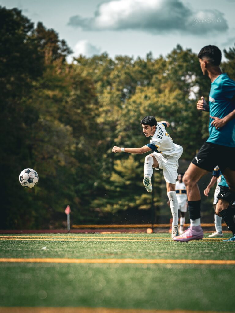 Soccer player wearing NECC uniform strikes ball