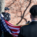 Police officer clips flag to pole