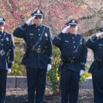 members of the lawrence police color guard salute flag