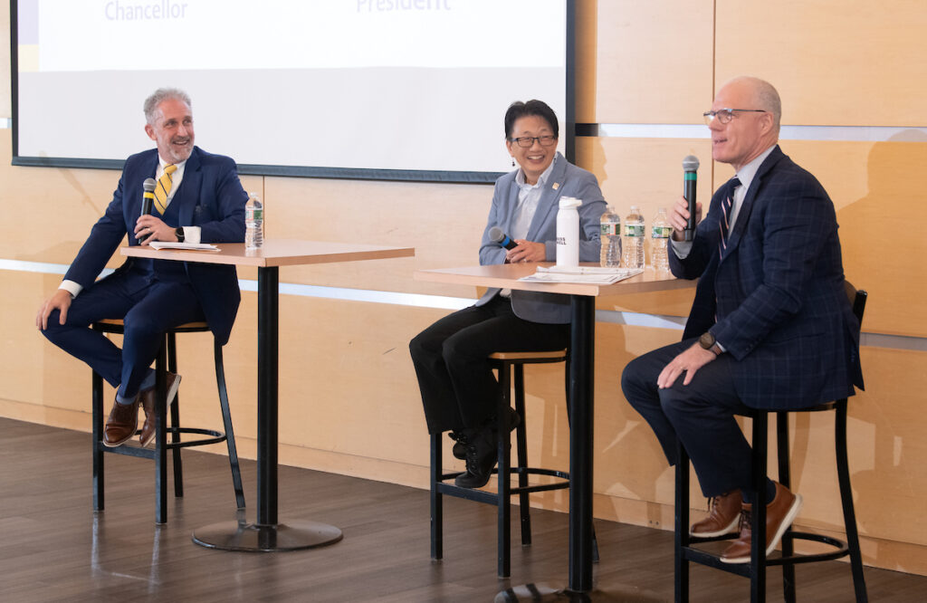 presdent glenn, Chancellor Chen, and president Keenan sit at high top tables with microphones, addressing the audience