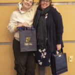 two women pose with their gift bags