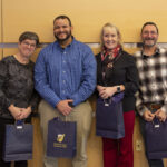 two men and two women pose with their gift bags