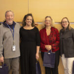 a man and three women pose with their gift bags