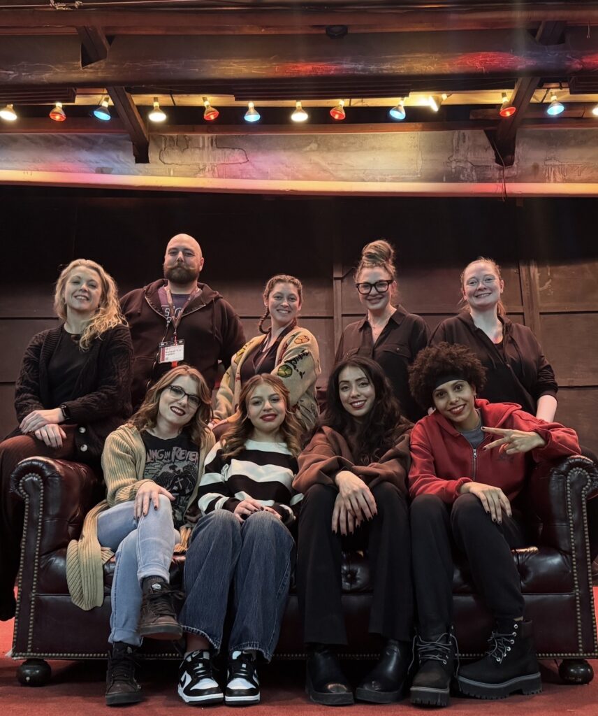 group of students pose on a stage smiling at camera