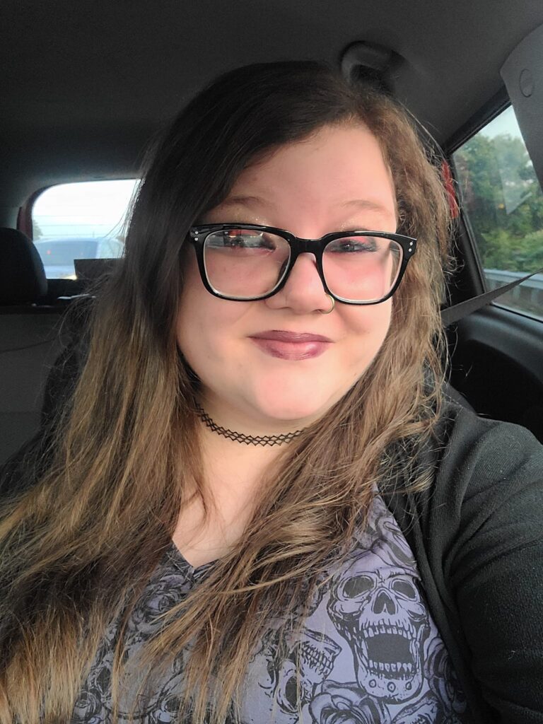 Selfie of Dorothy in the car, She wears glasses and has long brown hair
