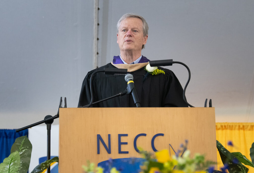 charlie baker stands behind podium and addresses the crowd