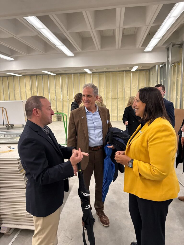 lt governor driscoll stands in room with construction, talking to college leadership
