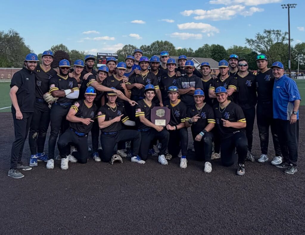 KNights team stands in black uniforms with black hats holding tournament trophy