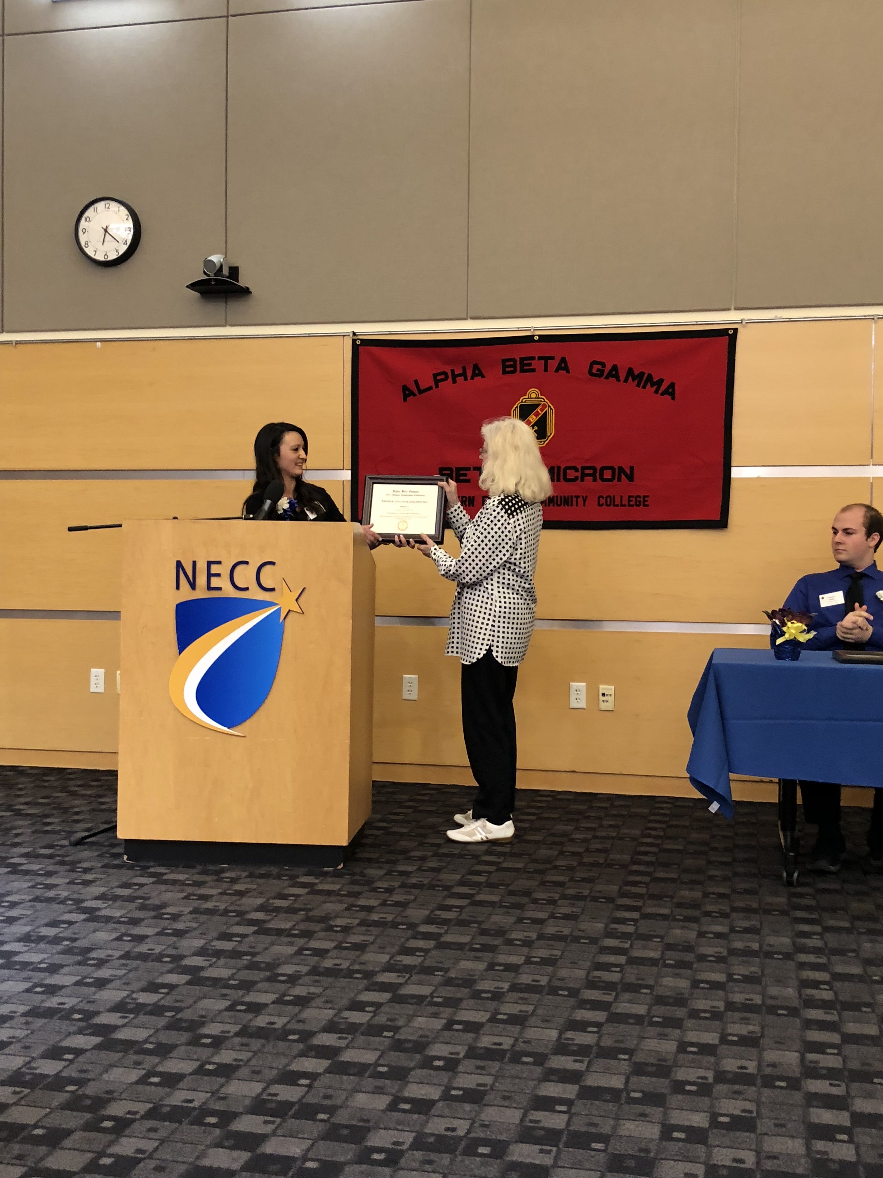 A student is inducted into Alpha Beta Gamma