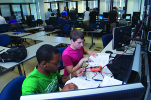 Engineering students analyzing an electronic circut 